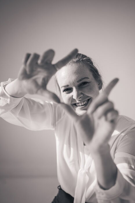 Fotografin symbolisiert mit ihren Händen eine Kamera